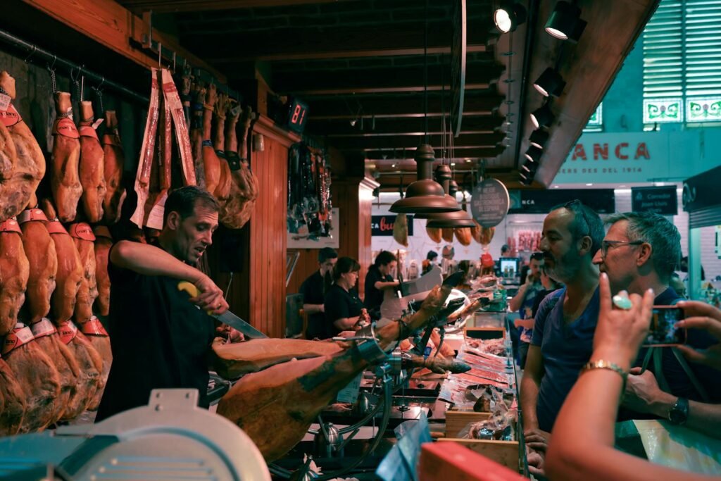 A bustling Barcelona market scene featuring a butcher slicing authentic Spanish jamón.